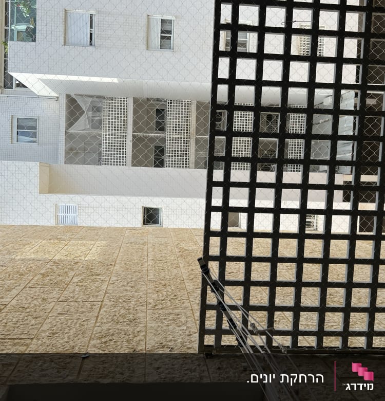 רשת מתכת על חלון למניעת כניסת יונים